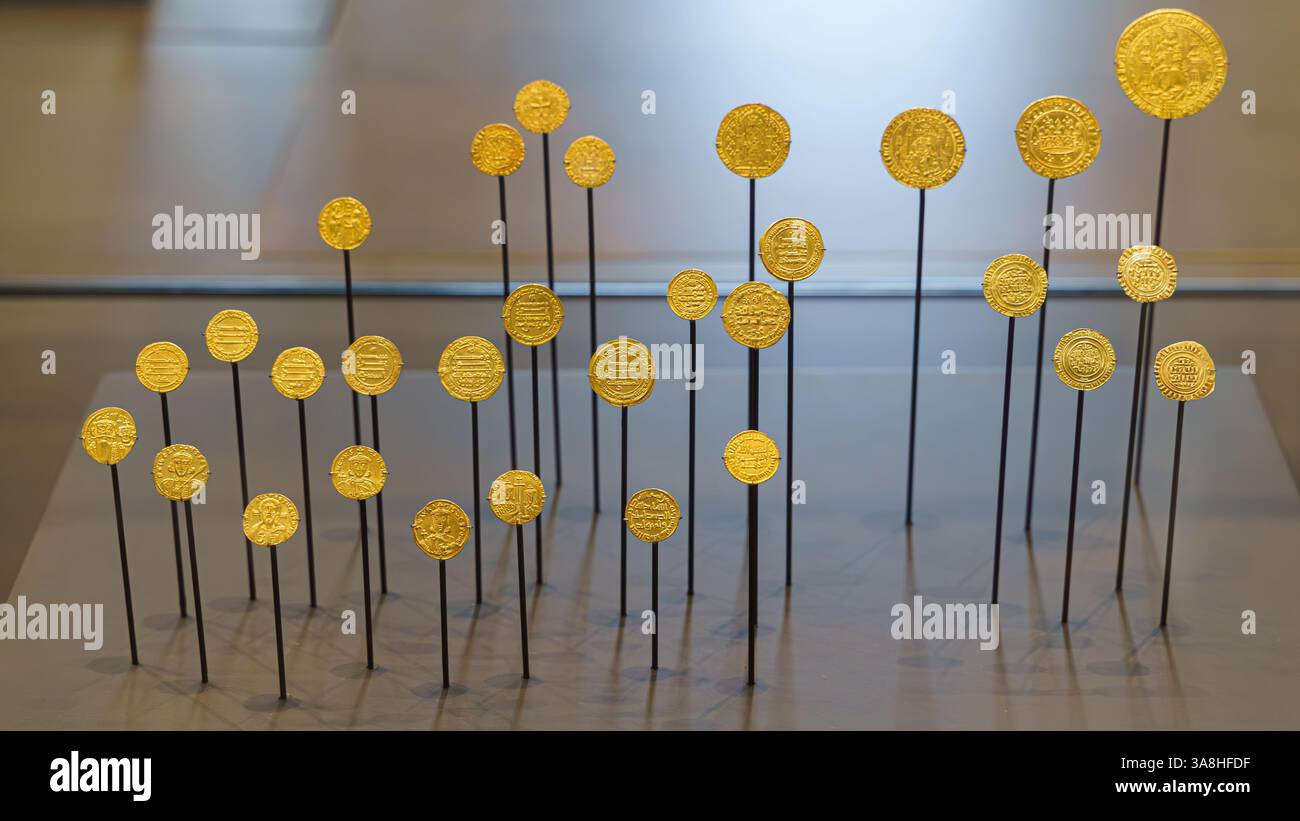 Abu Dhabi, Vereinigte Arabische Emirate - 17. Januar 2024, Nahaufnahme der alten Goldmünzen auf Ständen, Ausstellung des Museums Louvre Abu Dhabi, VAE Stockfoto