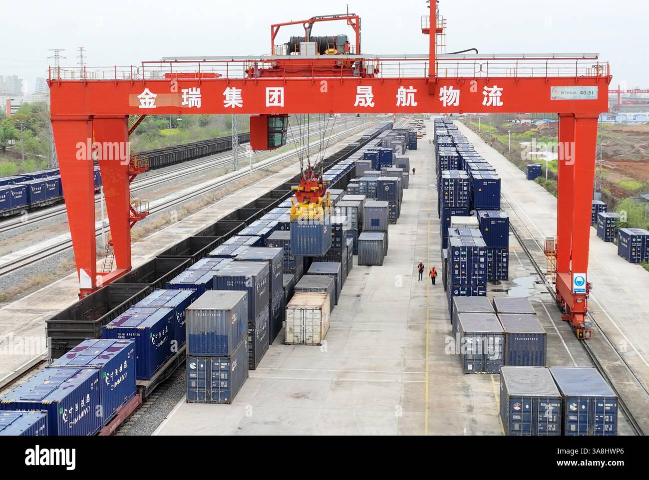 Ein Portalkran hebt Getreidebehälter in einen Zugwagen auf der speziellen Eisenbahnlinie des Hafens Jiujiang Chengxi in Jiujiang, Provinz Jiangxi, China weiter Stockfoto