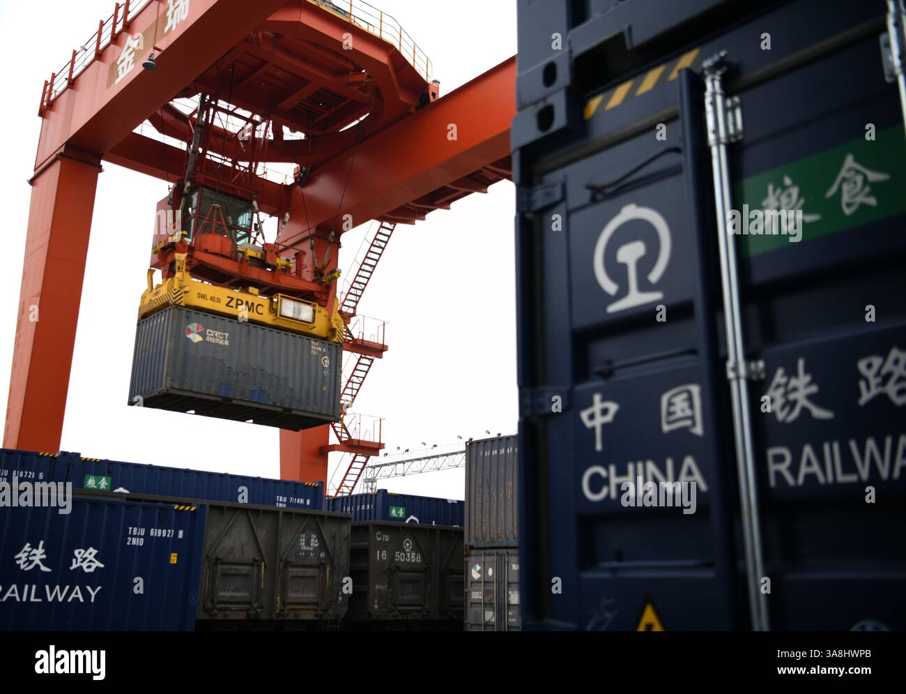 Ein Portalkran hebt Getreidebehälter in einen Zugwagen auf der speziellen Eisenbahnlinie des Hafens Jiujiang Chengxi in Jiujiang, Provinz Jiangxi, China weiter Stockfoto