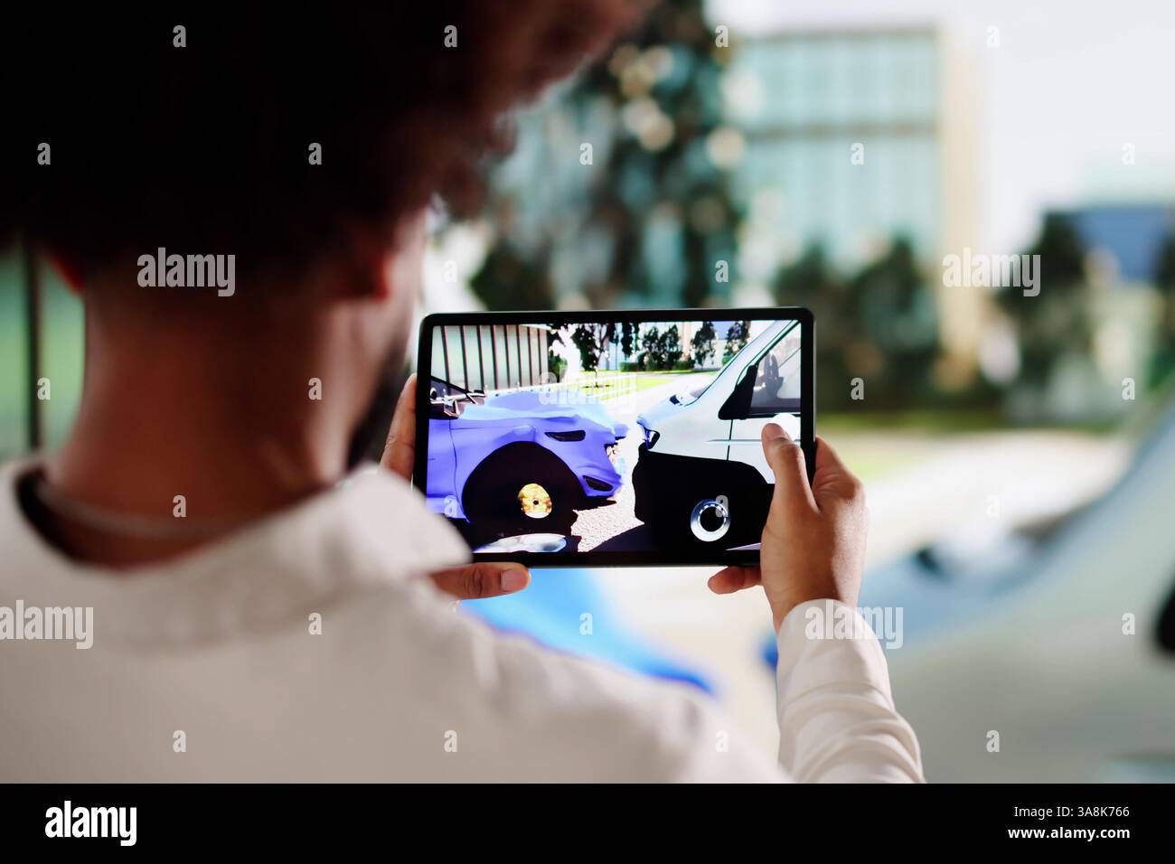 Fahrer in blauem Anzug dokumentiert Autoschäden für Versicherungsansprüche. Stockfoto