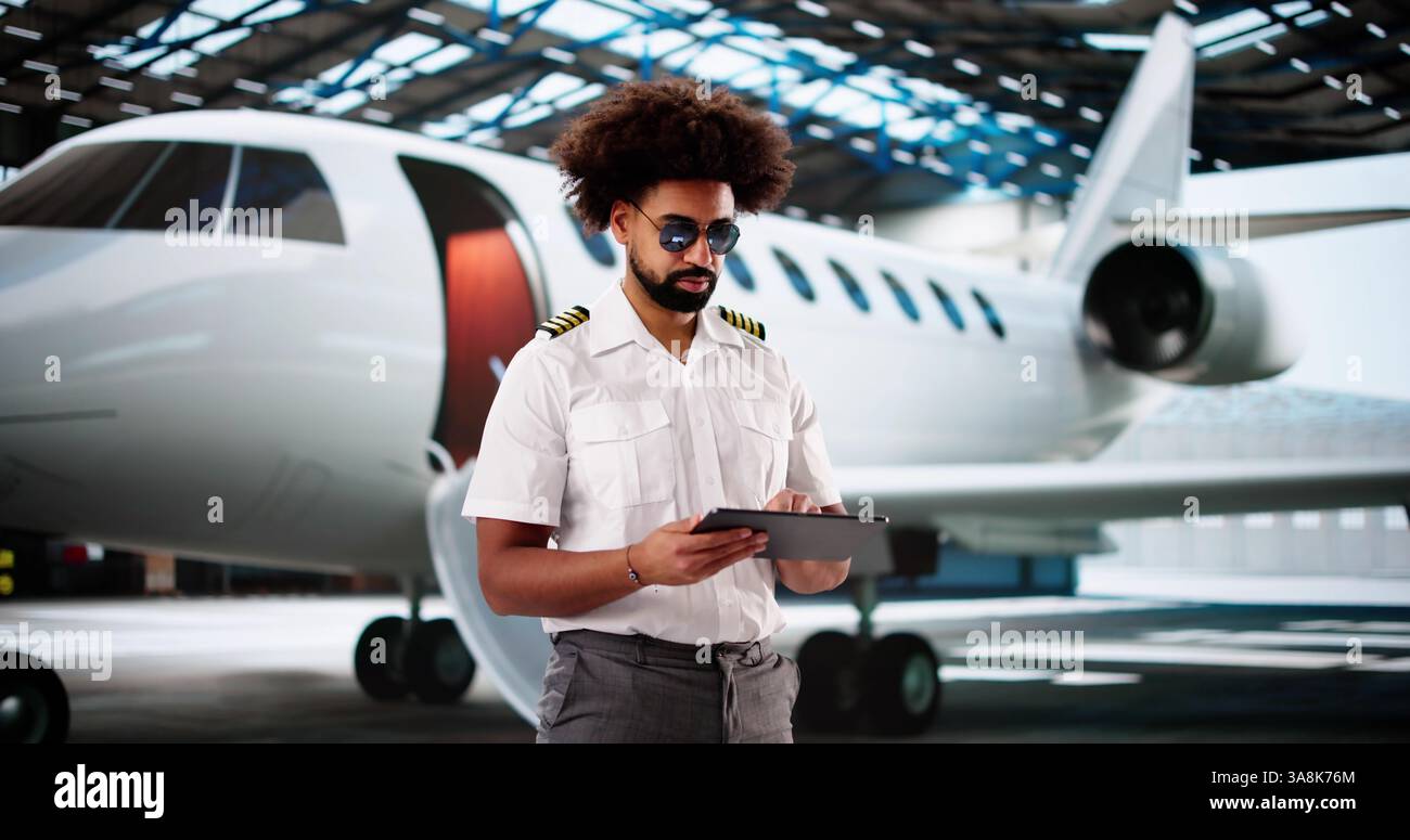 Fröhlicher afroamerikanischer Pilot mit Tablet für die Wartungs-Checkliste vor dem Flug. Stockfoto