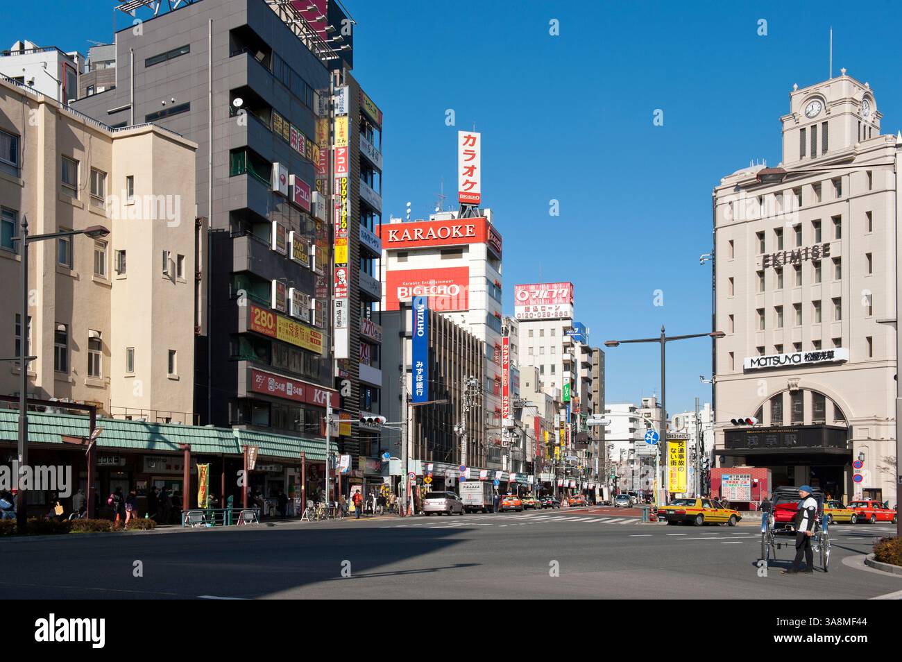Ein Jinrikisha (Rikscha)-Läufer wartet auf einen Kunden entlang der Umamichi-dori Straße vor dem Bahnhof der Tobu-Linie in Asakusa, Tokio, Japan. Stockfoto
