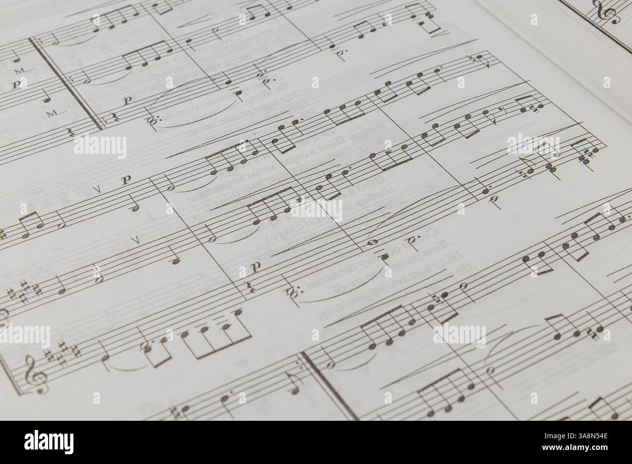 Die Notation ist auf einer hellen Oberfläche ordentlich angeordnet und zeigt verschiedene Noten und Rhythmen. Das Notenblatt scheint gut benutzt zu sein, was auf eine Geschichte hindeutet Stockfoto