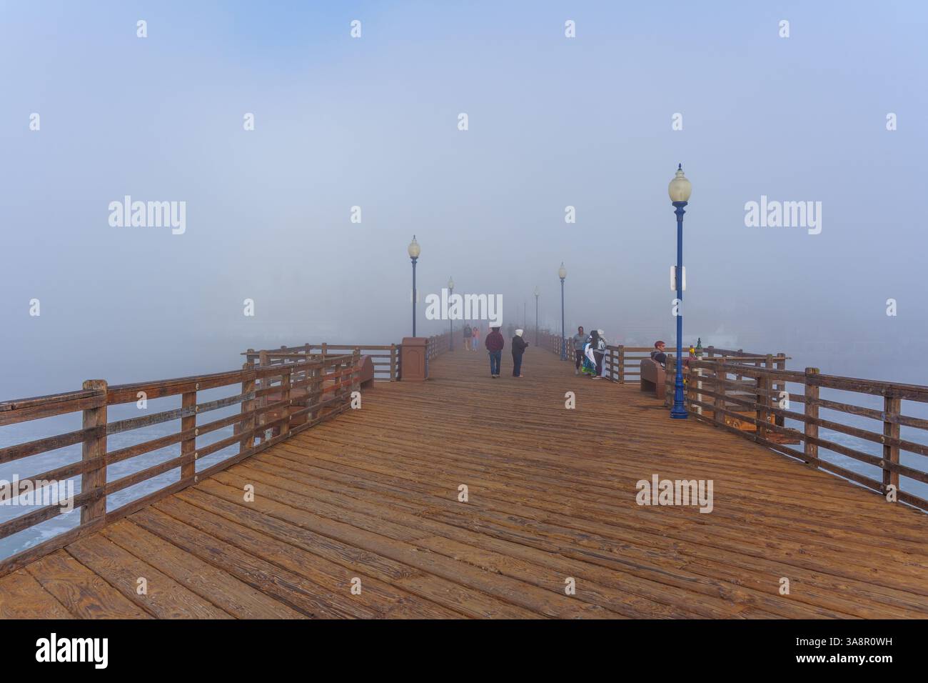 Oceanside, Kalifornien - 3. Januar 2025: Malerischer Blick auf den Oceanside Municipal Pier in Kalifornien, bei dem Menschen spazieren gehen und die nebelige Atmosphäre genießen Stockfoto