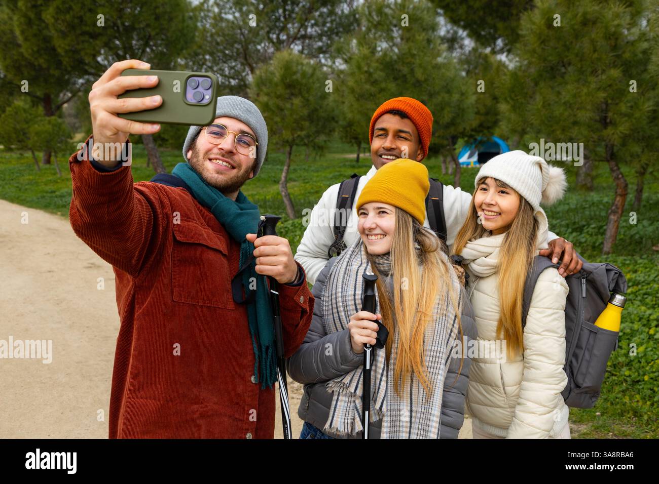 Gruppe junger Wanderer, die ein Selfie mit Smartphone machen, während sie einen Trekkingtag im Wald genießen Stockfoto