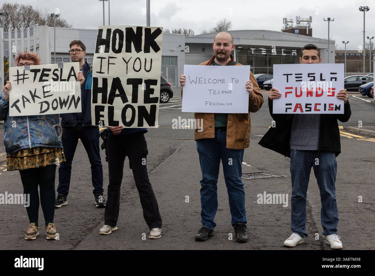 Glasgow, Großbritannien, 29. März 2025. Demonstranten halten Schilder an den Toren eines Tesla Showrooms, um gegen Elon Musk zu protestieren, an einem globalen Aktionstag der Basisbewegung ÔTesla TakedownÕ, am 29. März 2025 in Glasgow, Schottland. Foto: Jeremy Sutton-Hibbert/ Alamy Live News. Stockfoto