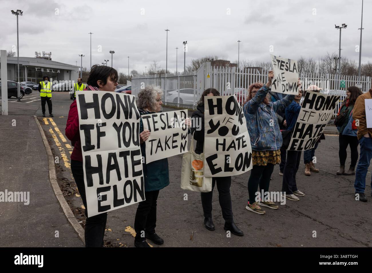 Glasgow, Großbritannien, 29. März 2025. Demonstranten halten Schilder an den Toren eines Tesla Showrooms, um gegen Elon Musk zu protestieren, an einem globalen Aktionstag der Basisbewegung ÔTesla TakedownÕ, am 29. März 2025 in Glasgow, Schottland. Foto: Jeremy Sutton-Hibbert/ Alamy Live News. Stockfoto