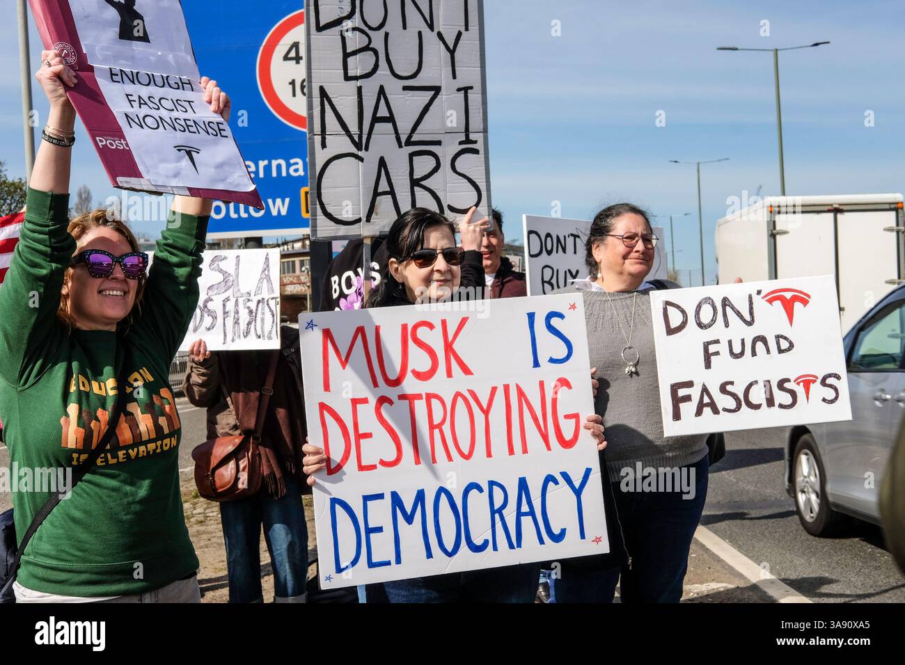 März 2025, London, Großbritannien. Demonstranten gegen Elon Musk und seine politischen Aktionen bei der US-Kundgebung vor dem Tesla Car Showroom im Park Royal, London. Der Londoner Protest ist Teil eines globalen Aktionstages unter dem Dach der Tesla Takedown-Bewegung. Die Organisatoren sagen, dass die Kundgebungen vor mehr als 200 Tesla-Standorten weltweit stattfinden werden. Die Demonstranten ermutigen die Autofahrer, beim Besuch des Tesla Showrooms in London die Hupe zu läuten. Stockfoto