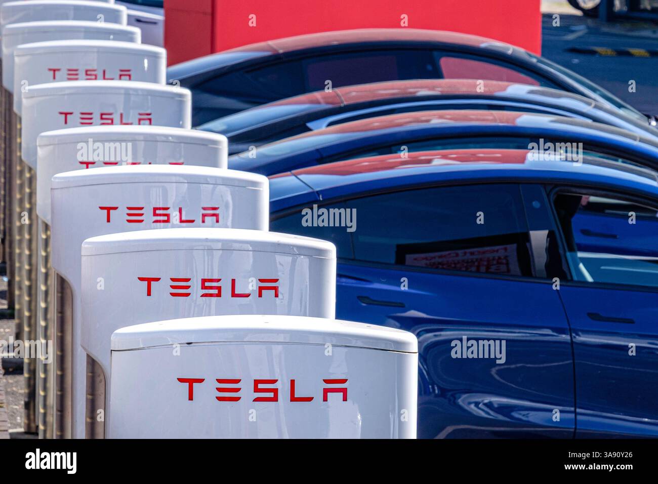 Eine Reihe von Tesla-Fahrzeugen auf dem Vorplatz des Londoner Ausstellungsraums des Autoherstellers, Park Royal, London, Großbritannien. Stockfoto