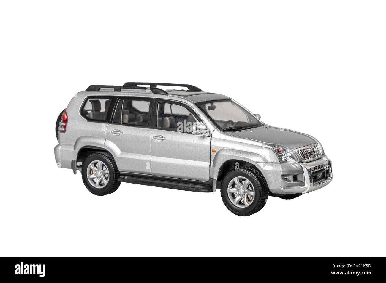 Ein silbernes Spielzeugmodell TOYOTA PRADO Geländewagen steht auf weißem Hintergrund. Das Auto ist glänzend und gut gepflegt und vermittelt ein Gefühl von Luxus und so Stockfoto