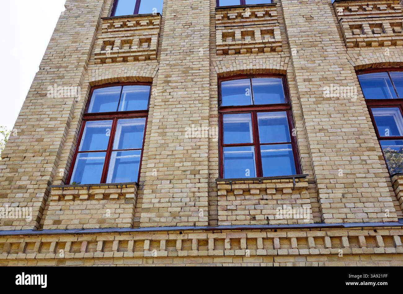 Klassische Backsteinfassade eines Gebäudes aus dem 19. Jahrhundert mit großen Fenstern. Altes Gebäude in Kiew, Ukraine Stockfoto