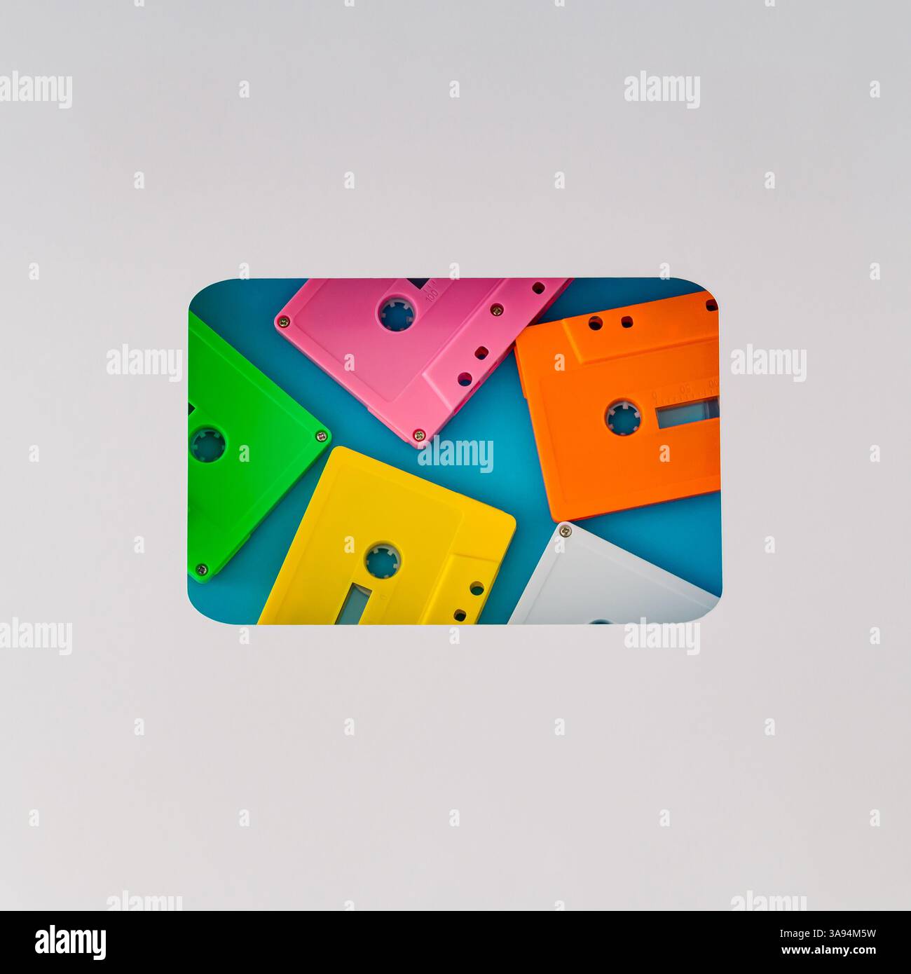 Layout im Vintage-Stil mit bunten alten Audiokassettenkassetten, sichtbar durch eine kassettenförmige Lücke auf blauem Hintergrund. Kreatives Konzept des Retro t Stockfoto