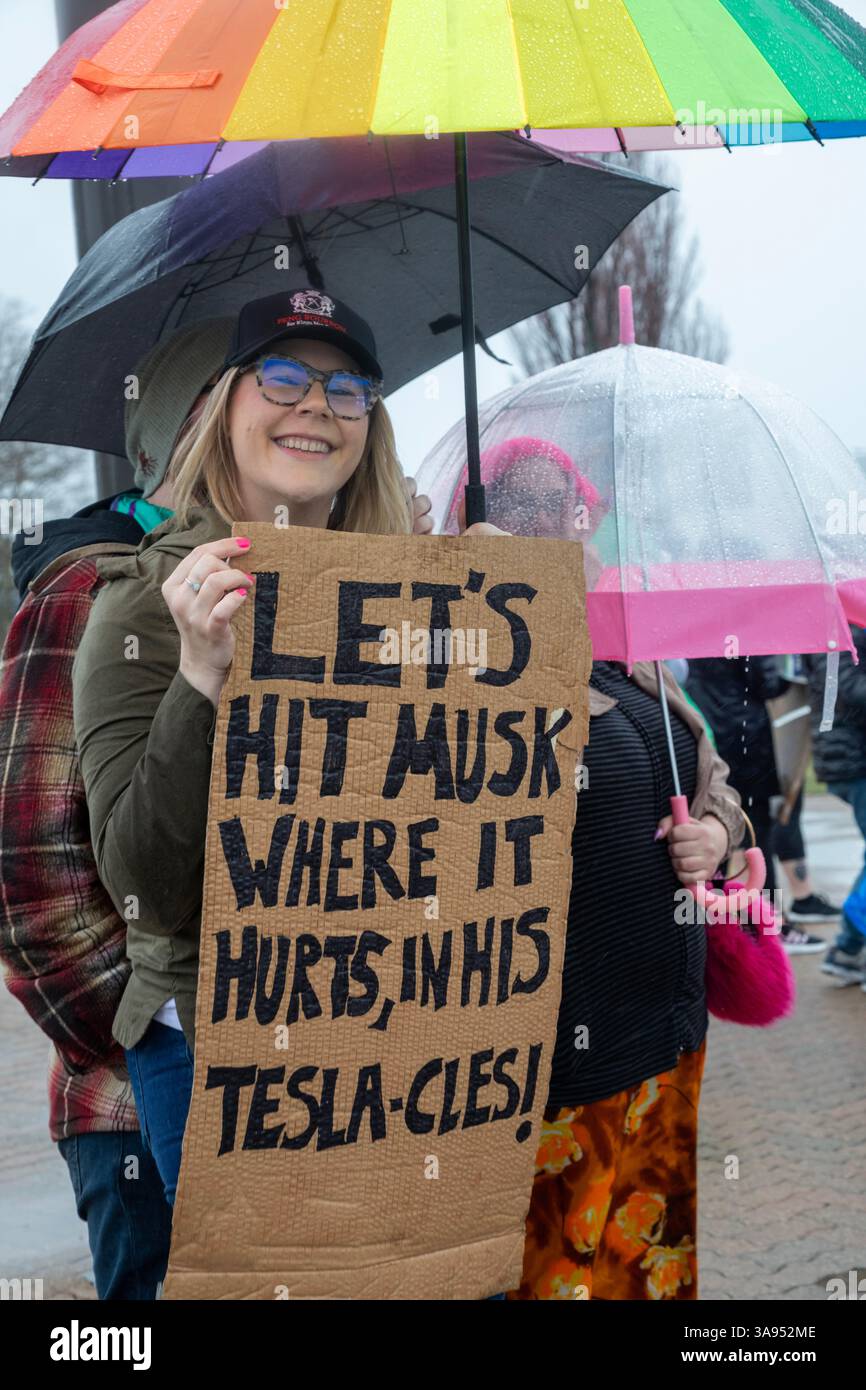 Troy, Michigan, USA. März 2025. Menschen versammelten sich im Regen vor dem Tesla Showroom in der Somerset Mall, um gegen die Rolle des Tesla-Besitzers Elon Musk bei der Zerschlagung der Regierungsdienste zu protestieren. Es war eine von vielen „Tesla Takedown“-Aktionen, die im ganzen Land und im Ausland geplant waren. Quelle: Jim West/Alamy Live News Stockfoto