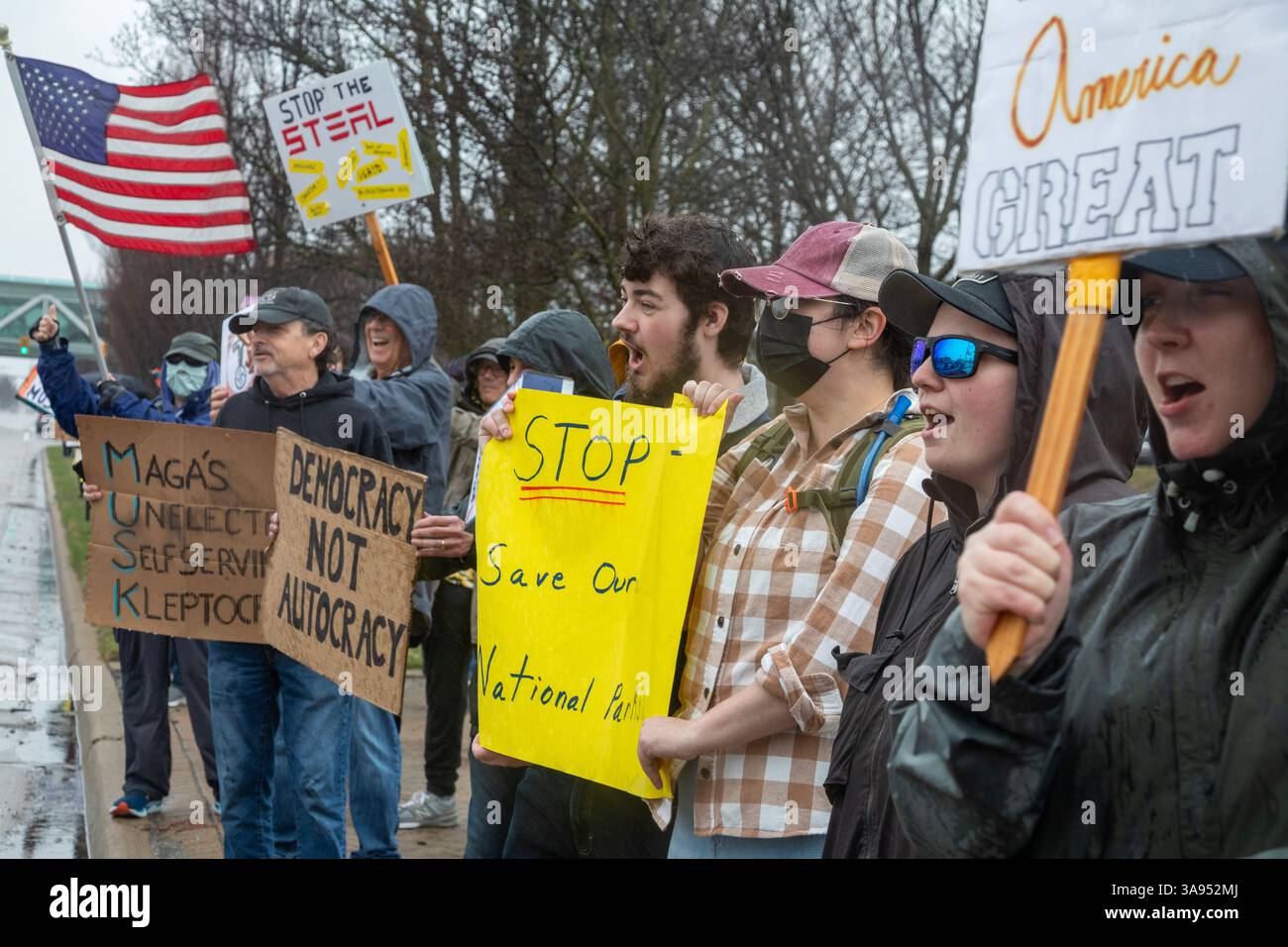 Troy, Michigan, USA. März 2025. Menschen versammelten sich im Regen vor dem Tesla Showroom in der Somerset Mall, um gegen die Rolle des Tesla-Besitzers Elon Musk bei der Zerschlagung der Regierungsdienste zu protestieren. Es war eine von vielen „Tesla Takedown“-Aktionen, die im ganzen Land und im Ausland geplant waren. Quelle: Jim West/Alamy Live News Stockfoto