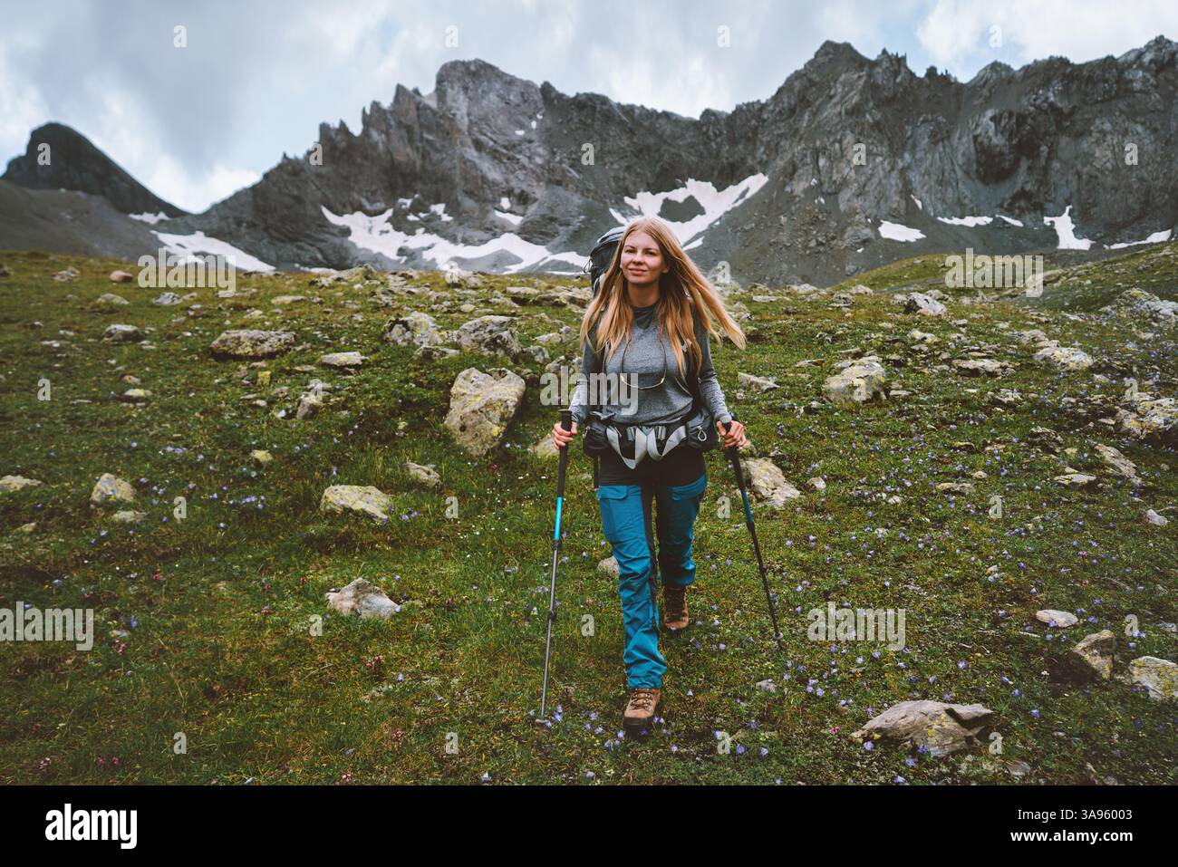 Junge Frau Wandern in den Bergen mit Trekkingstöcken und Rucksackausrüstung, Reise Solo Abenteuer Lifestyle weibliche Reisende Trekking Aktivurlaub Outdo Stockfoto