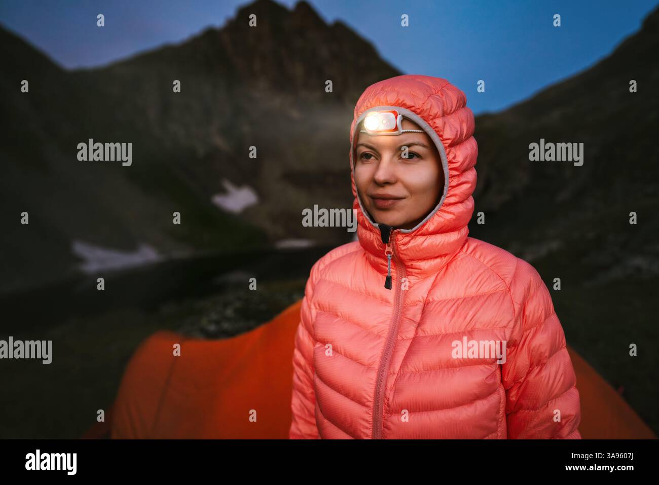 Frau mit Stirnlampe Campingausrüstung in Nacht Berge, Mädchen Reisen Wandern Outdoor Klettern Abenteuer aktive gesunde Lebensstil Urlaub Reise Stockfoto