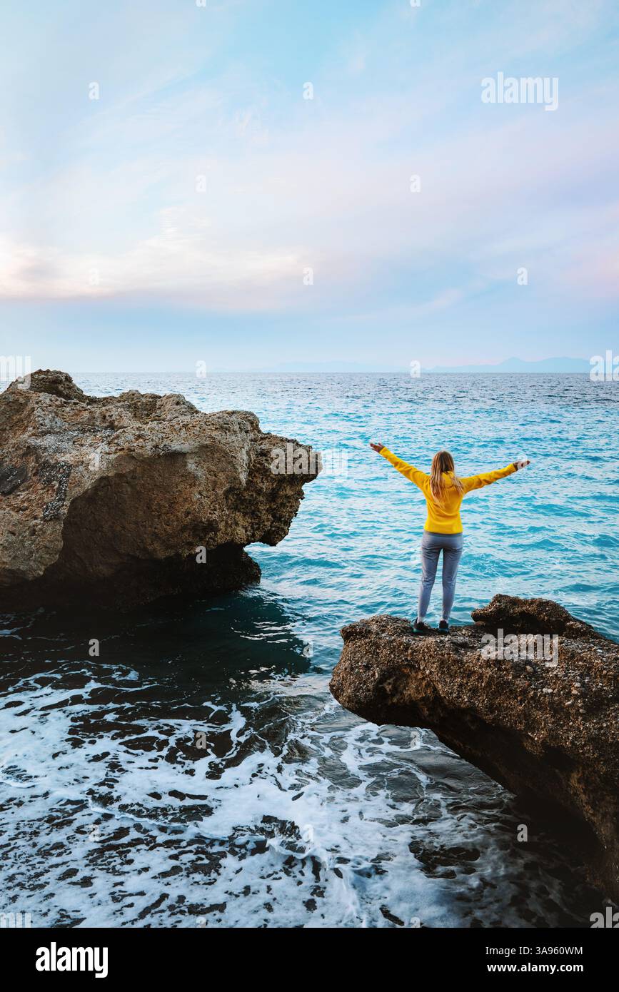 Frau, die alleine in Griechenland reist, genießt Meerblick Sommerurlaub im Freien, touristische Mädchen, die Rhodos Insel erkunden Harmonie mit der Natur glücklich erhobene Hände Stockfoto