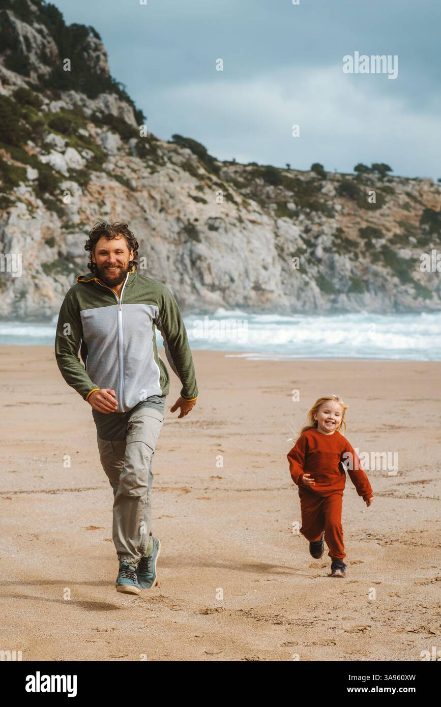 Familie Vater und Kind spielen am Sandstrand Reisen in Griechenland im Freien, Sommer Aktivurlaub Lifestyle Vater und Kind laufen und lachen miteinander Stockfoto