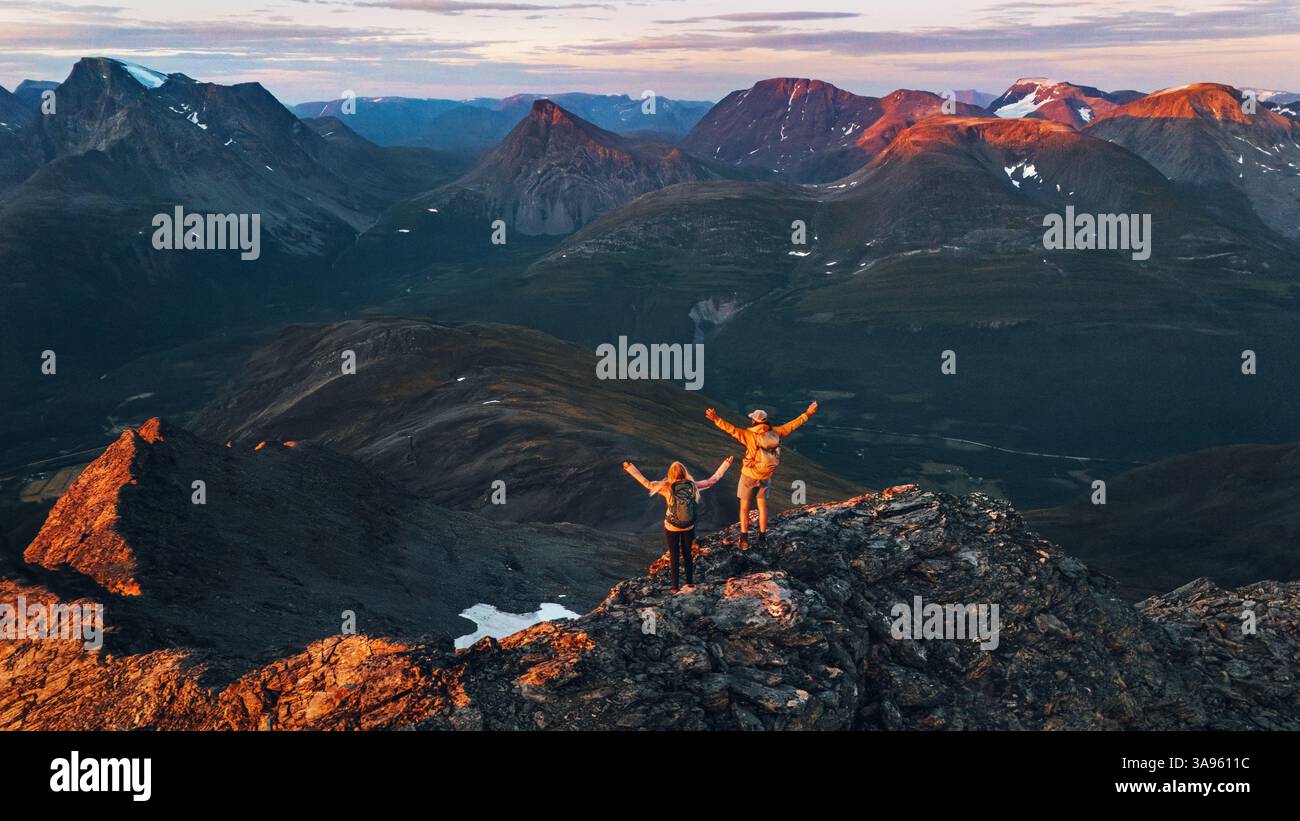 Paare Wandern in Norwegen Mann und Frau Freunde erhobenen Hände genießen Luft Sonnenuntergang Berge Aussicht, aktiven Urlaub gesunde Lebensstil Tour Outdoor fami Stockfoto
