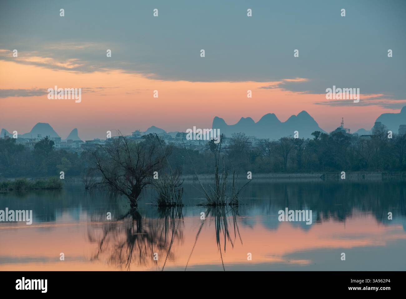 Golden Dawn am Li River: Misty Karst Peaks spiegeln sich in spiegelstigen Gewässern – Guiliins Ethereal Morning Symphony Stockfoto