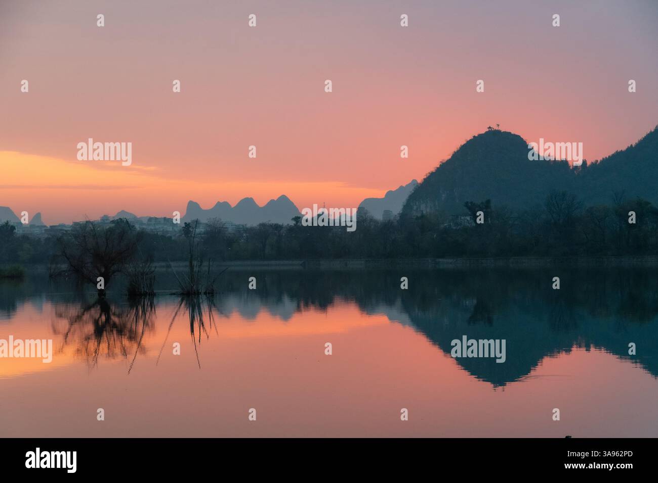 Golden Dawn am Li River: Misty Karst Peaks spiegeln sich in spiegelstigen Gewässern – Guiliins Ethereal Morning Symphony Stockfoto