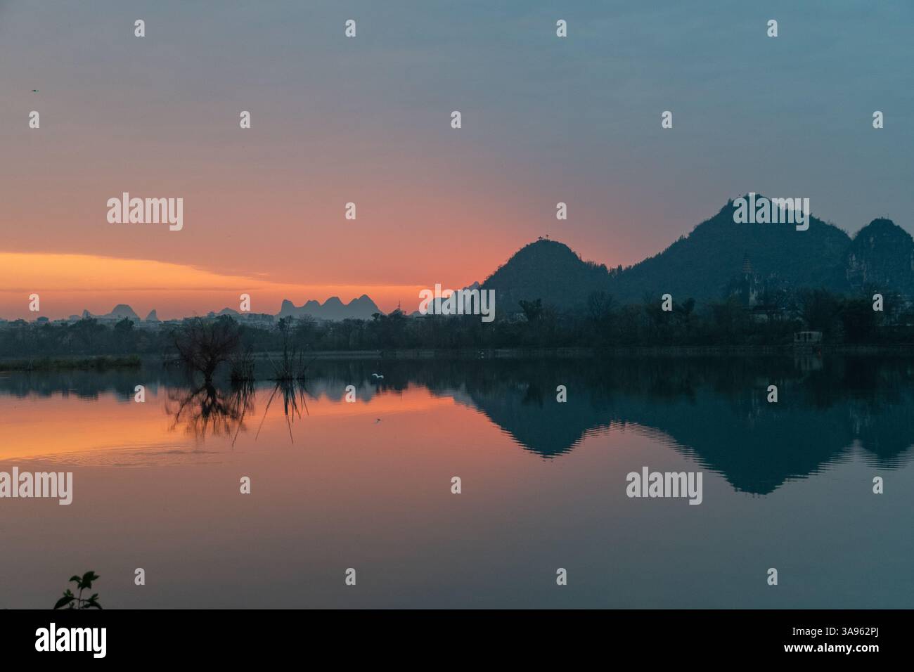 Golden Dawn am Li River: Misty Karst Peaks spiegeln sich in spiegelstigen Gewässern – Guiliins Ethereal Morning Symphony Stockfoto
