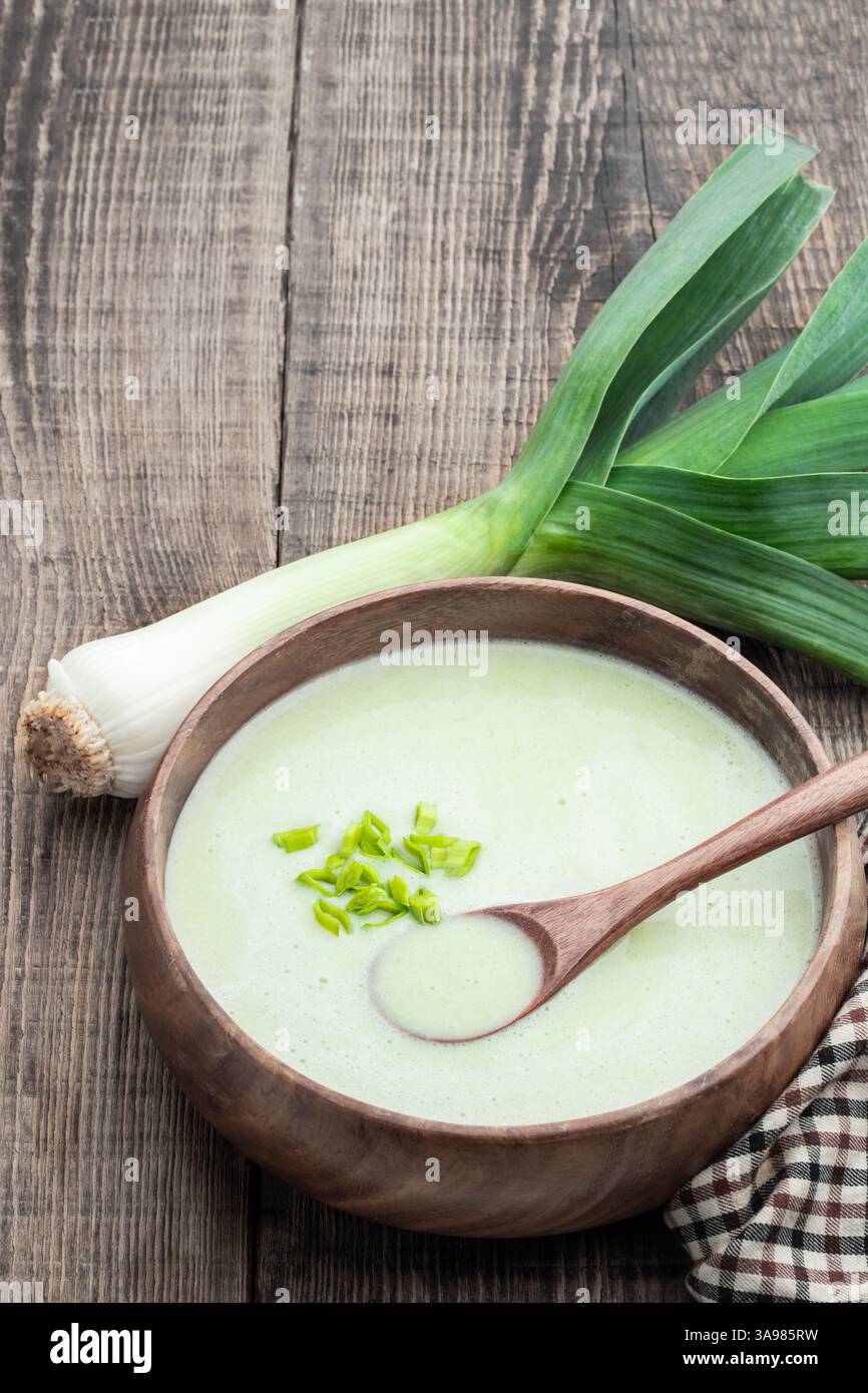 Cremige Lauch-Suppe in Holzschale auf rustikalem Tisch Stockfoto Cremige Lauch-Suppe in Holzschale auf rustikalem Tisch Stockfoto