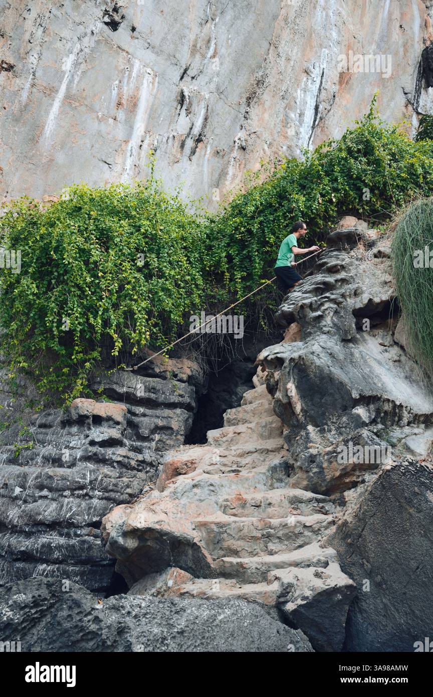 Der Wanderer steigt eine zerklüftete Steintreppe an, die in die Klippe in der Nähe von Tonsai gemeißelt wurde Stockfoto