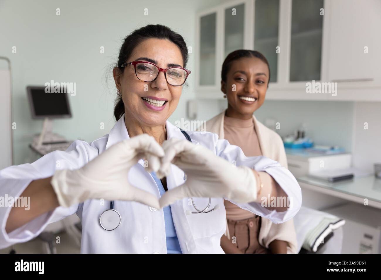 Positive reife Kardiologin-Ärztin mit Fingerherz Stockfoto