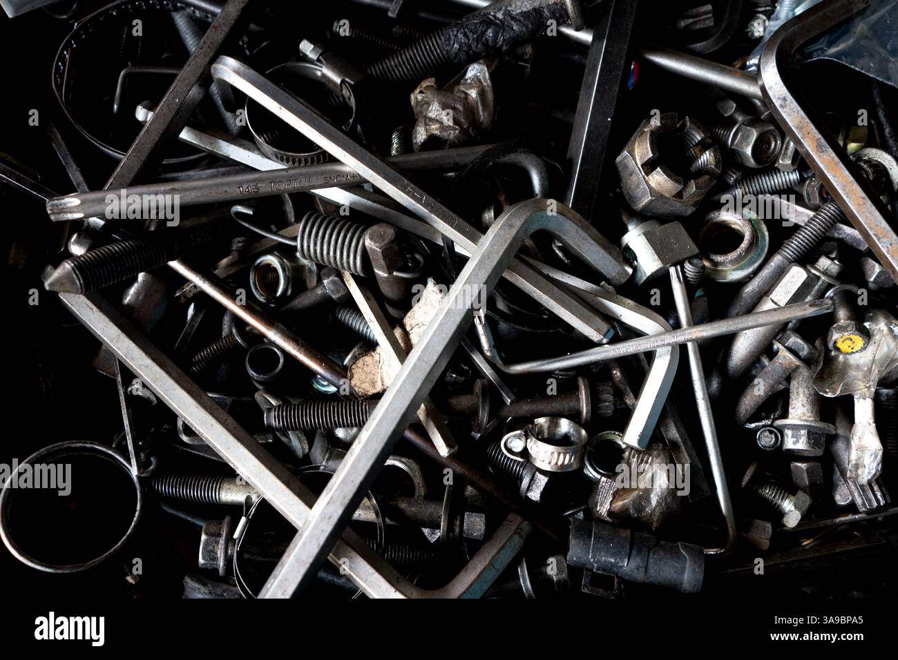 Ein unorganisiertes Sortiment an Metallwerkzeugen und Hardware-Komponenten. Stockfoto