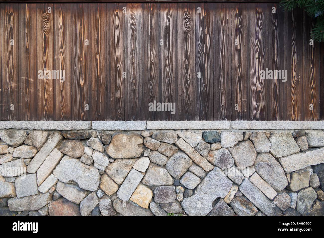 Shou sugi Ban, gebrannte Holzplatte im traditionellen japanischen Stil mit Steinsteinwand-Textur-Muster für Werbungshintergrund in japan Stockfoto