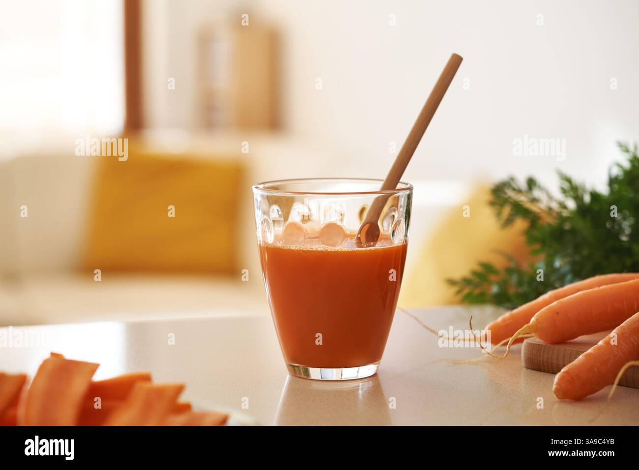 Karottensaft in einem Glasbecher mit Bambusstroh Stockfoto