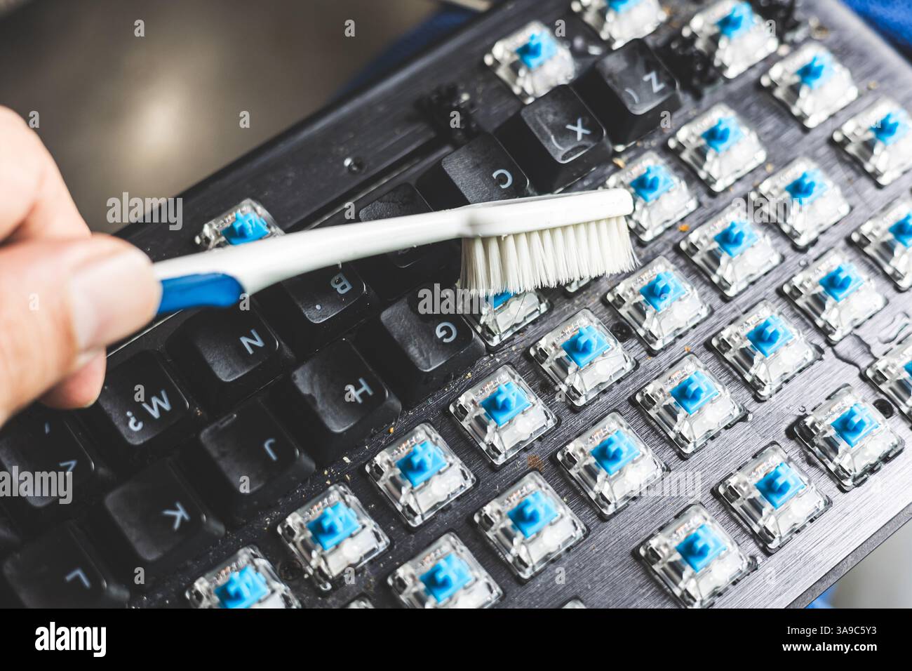 Großaufnahme mit alter Zahnbürste, schmutzige, staubige Computertastatur Stockfoto