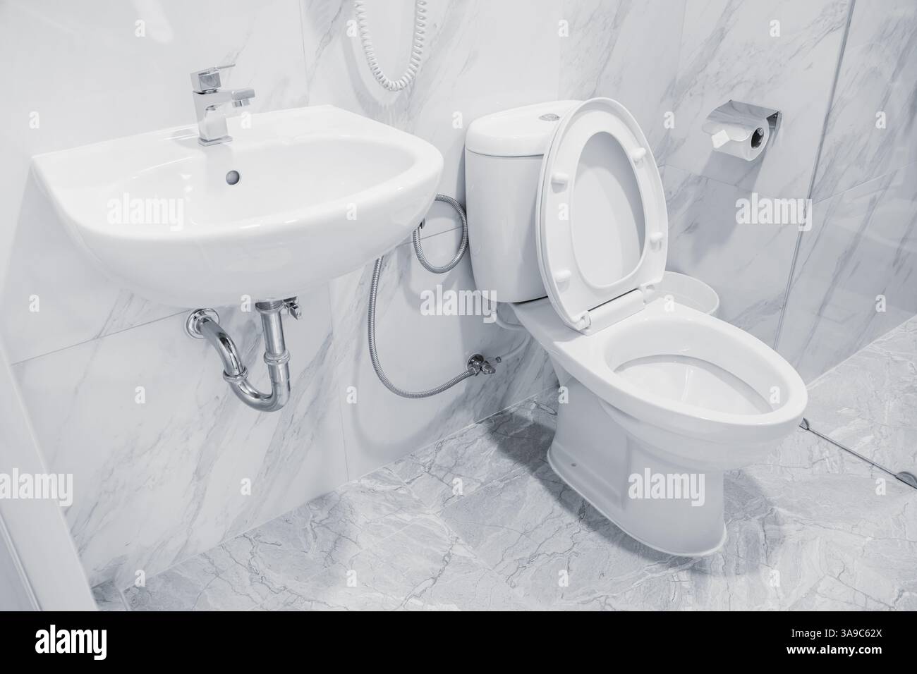 Saubere, neue, moderne Toilettenschüssel, Waschbecken im Hotelbad, Toilette weiß, Hygiene-Farbton Stockfoto