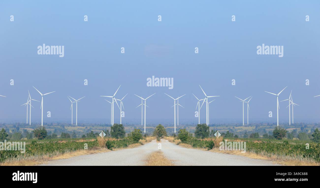 Windenergieanlage saubere Energie mit Straßenstraße auf dem Land grüne Energie Natur Hügel weite Panoramablick Landschaft mit blauem Himmel Stockfoto