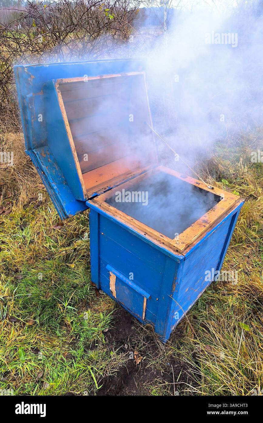 Detail eines brennenden Bienenstocks in einem Bienenhaus. Chemische Behandlung und Desinfektion durch Feuer und Rauch. Feuerwerkskörper können außer Kontrolle geraten und einen Brand verursachen Stockfoto