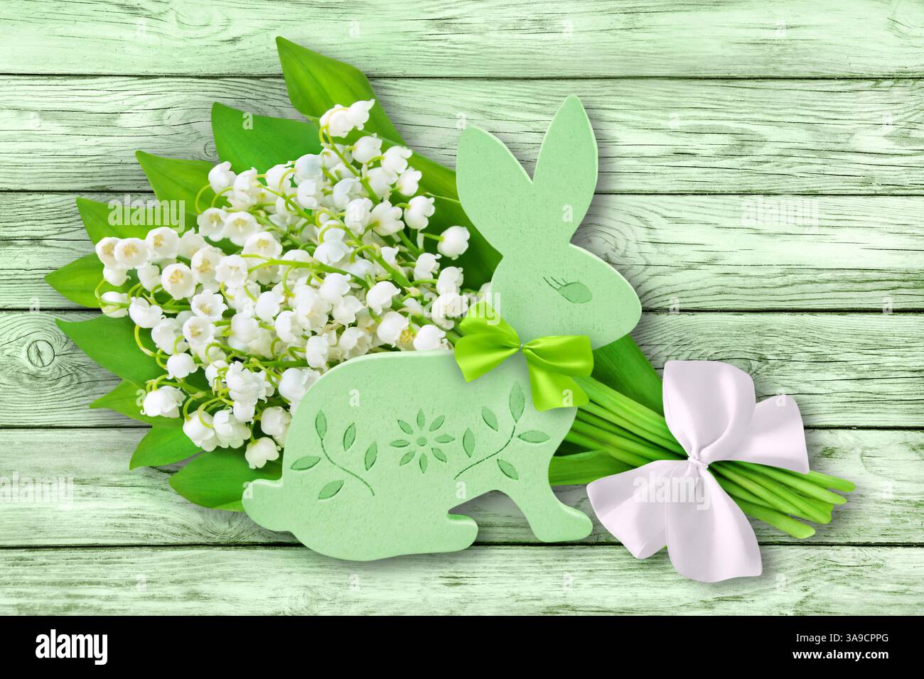 Grüner Osterhase mit Blumen auf hölzernem Hintergrund Stockfoto