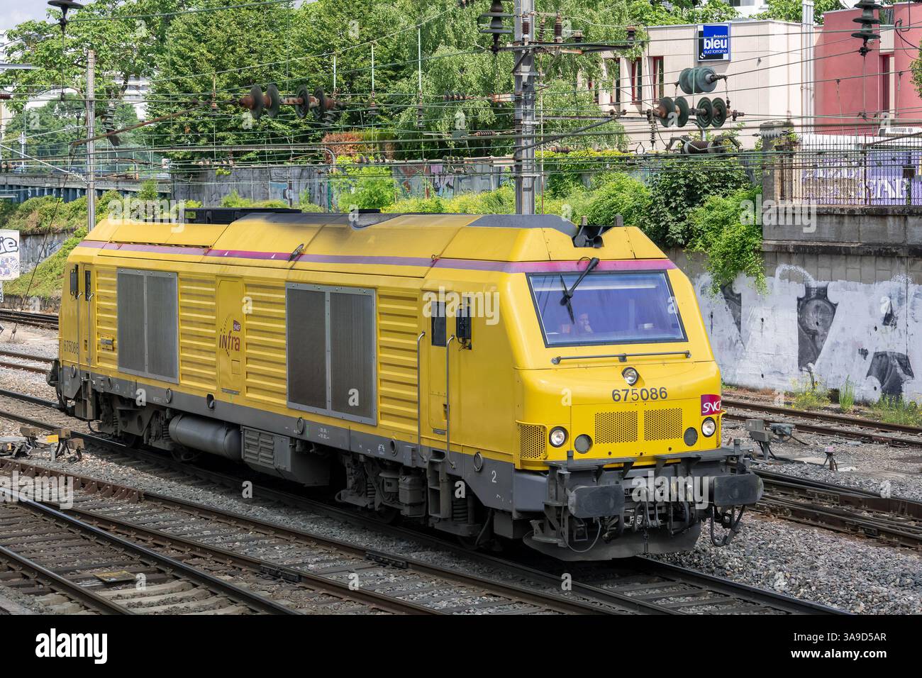 Nancy, Frankreich - Blick auf eine gelbe dieselelektrische Lokomotive Alstom - Siemens BB 75000 überquert den Bahnhof Nancy. Stockfoto