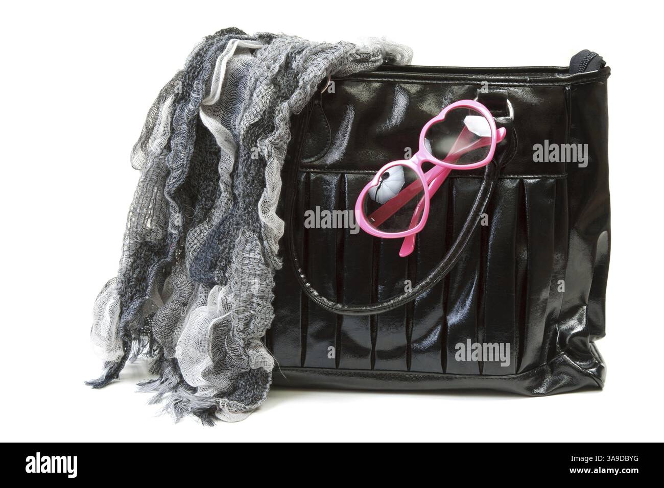 Feminine Tasche mit Schal und rosafarbenen Gläsern auf weißem Hintergrund Stockfoto
