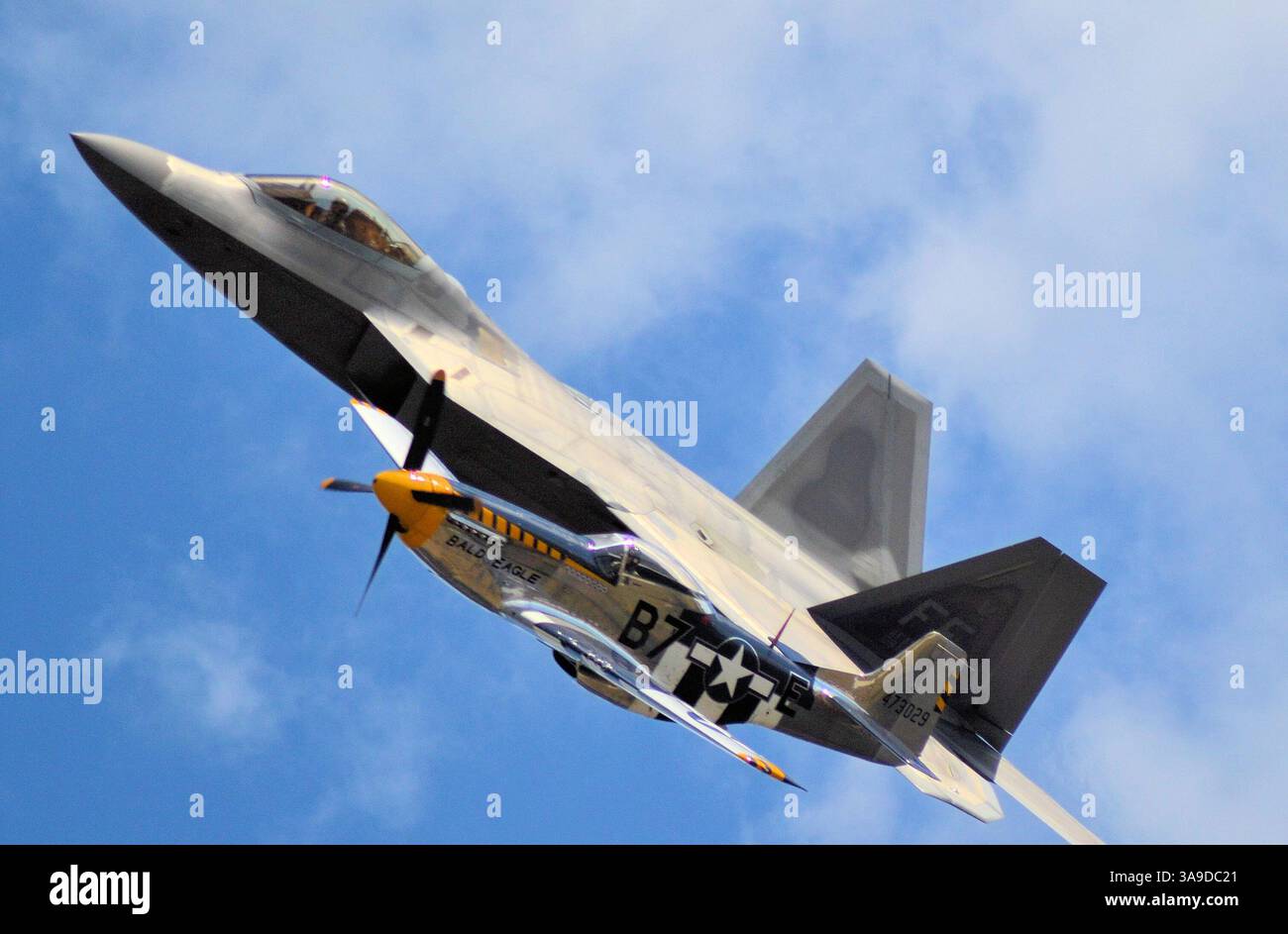Eine USAF Heritage Flight Formation bestehend aus einem P-51D Mustang aus dem 2. Weltkrieg und einem fortgeschrittenen F-22A Raptor, der während einer Flugschau fliegt Stockfoto