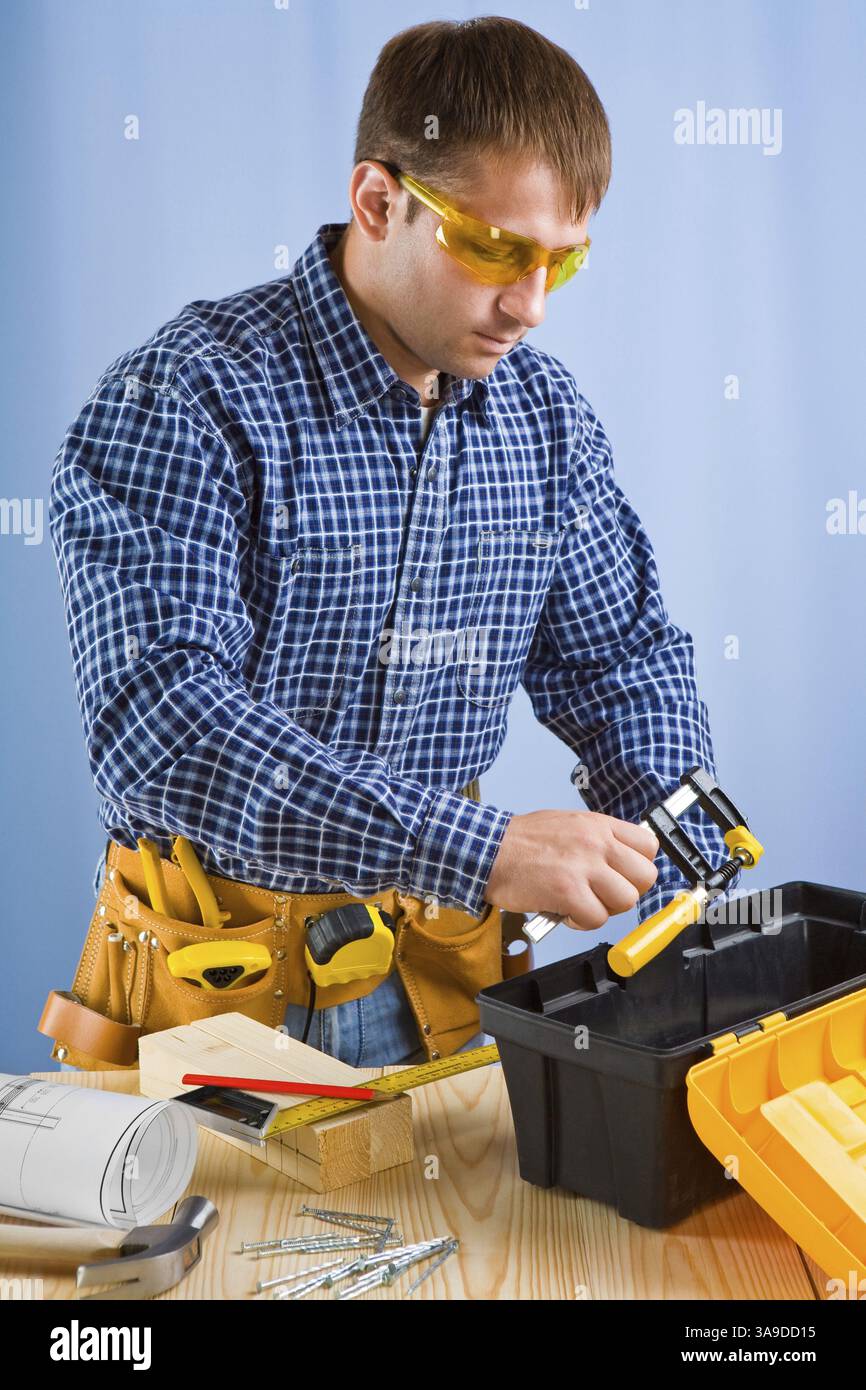 Der Arbeiter nimmt den Zimmerstock Stockfoto