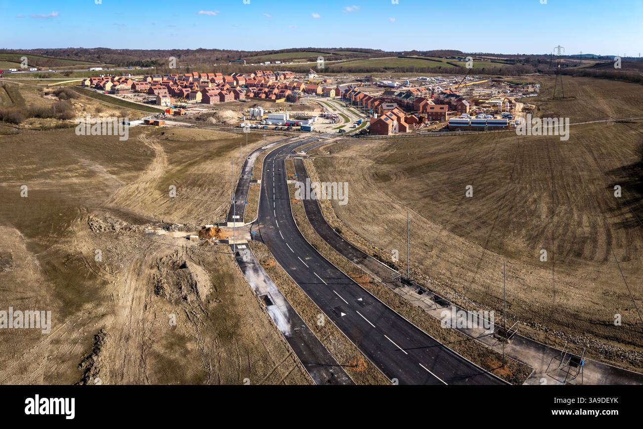 Aus der Vogelperspektive erschwingliche Neubauten auf einer Baustelle auf Grüngürtel mit neuer Straßeninfrastruktur, die neue Stadt in Großbritannien schafft Stockfoto