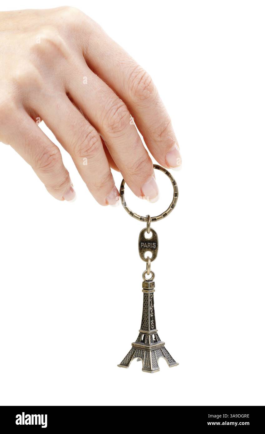Hand mit einer kleinen Eiffelturm-Statuette auf weißem Hintergrund Stockfoto