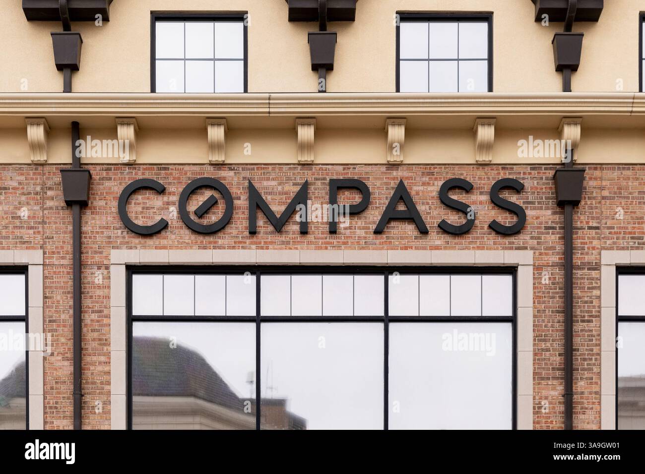 Das Compass Real Estate Logo auf einem Backsteingebäude in der Innenstadt von Naperville, IL. Stockfoto