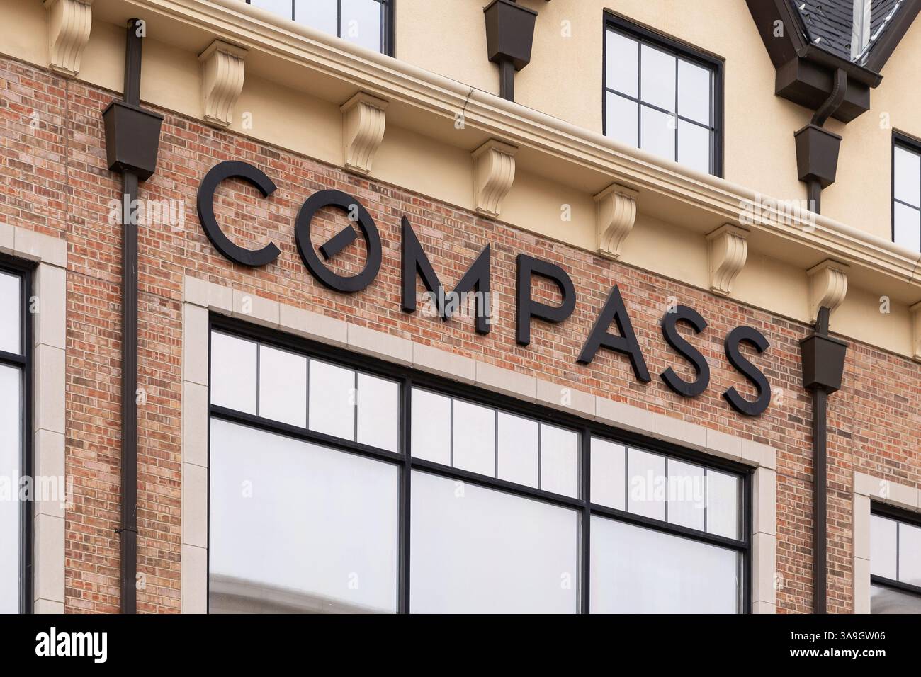 Das Compass Real Estate Logo auf einem Backsteingebäude in der Innenstadt von Naperville, IL. Stockfoto