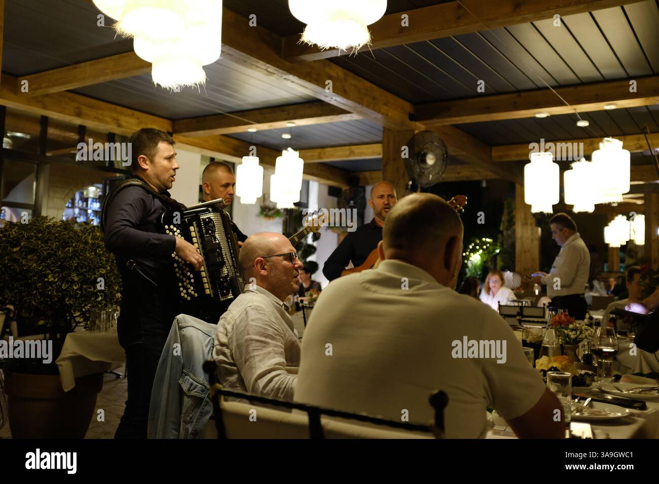 Männer essen in einem Restaurant und genießen Live-Musik Stockfoto