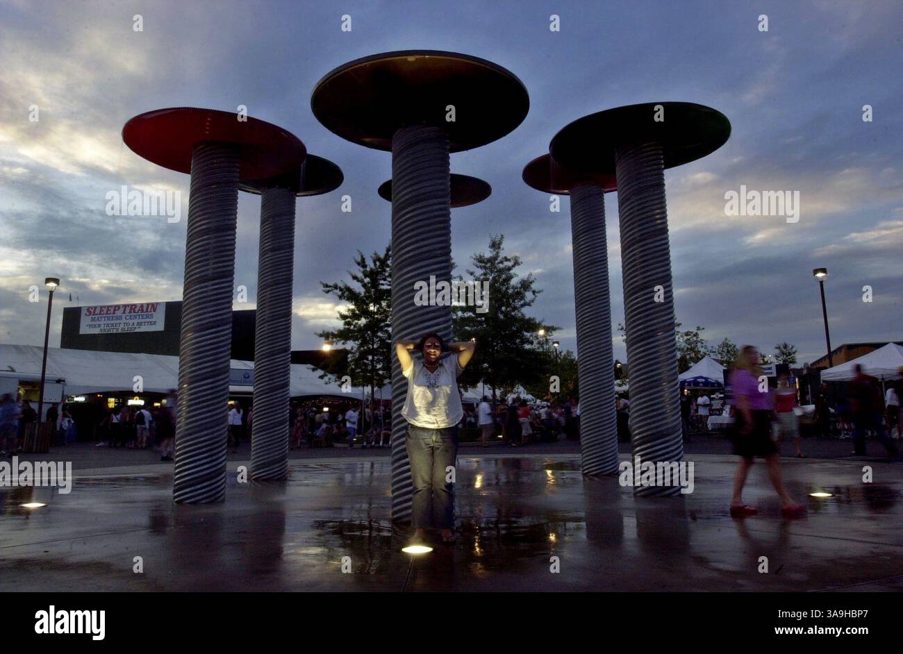 Konzertbesucher im Sleep Train Amphitheatre können sich in den heißen Sommernächten unter Springbrunnen im plaza abkühlen. Mittwoch, 28. Mai 2003. Sacramento Bee/Andy Alfaro/ZUMA Press Stockfoto