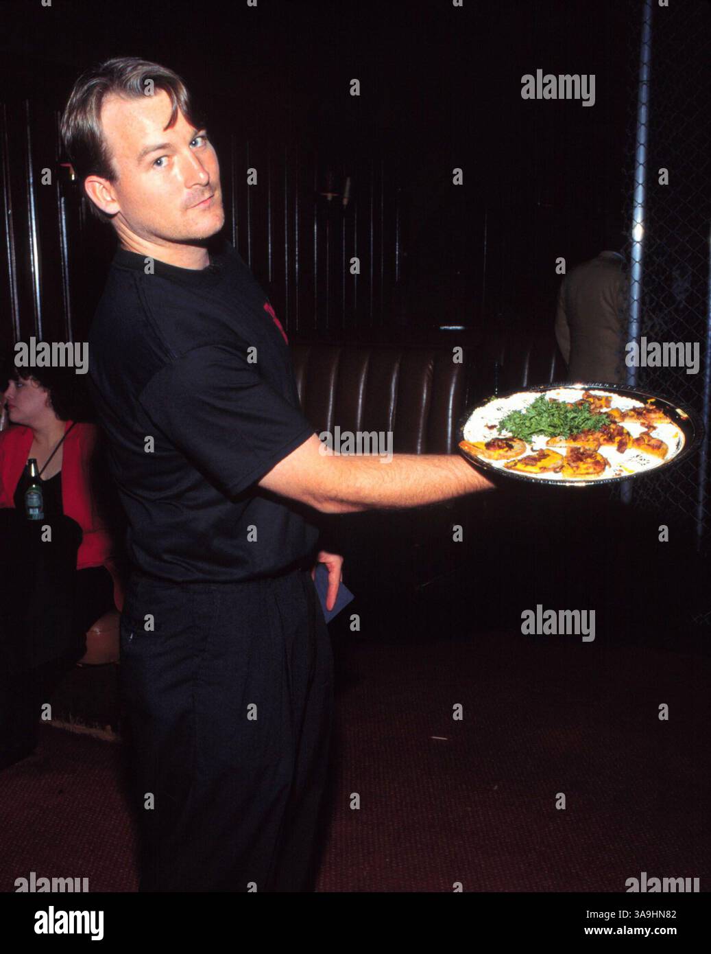 August 1997; Los Angeles, CA, USA; die Memphis Mafia-Videoveröffentlichung von All the King's Men. Hier zeigt ein Kellner Elvis' zweitbeliebtes Sandwich... gebrannter Speck und Senf auf Roggen. Stockfoto