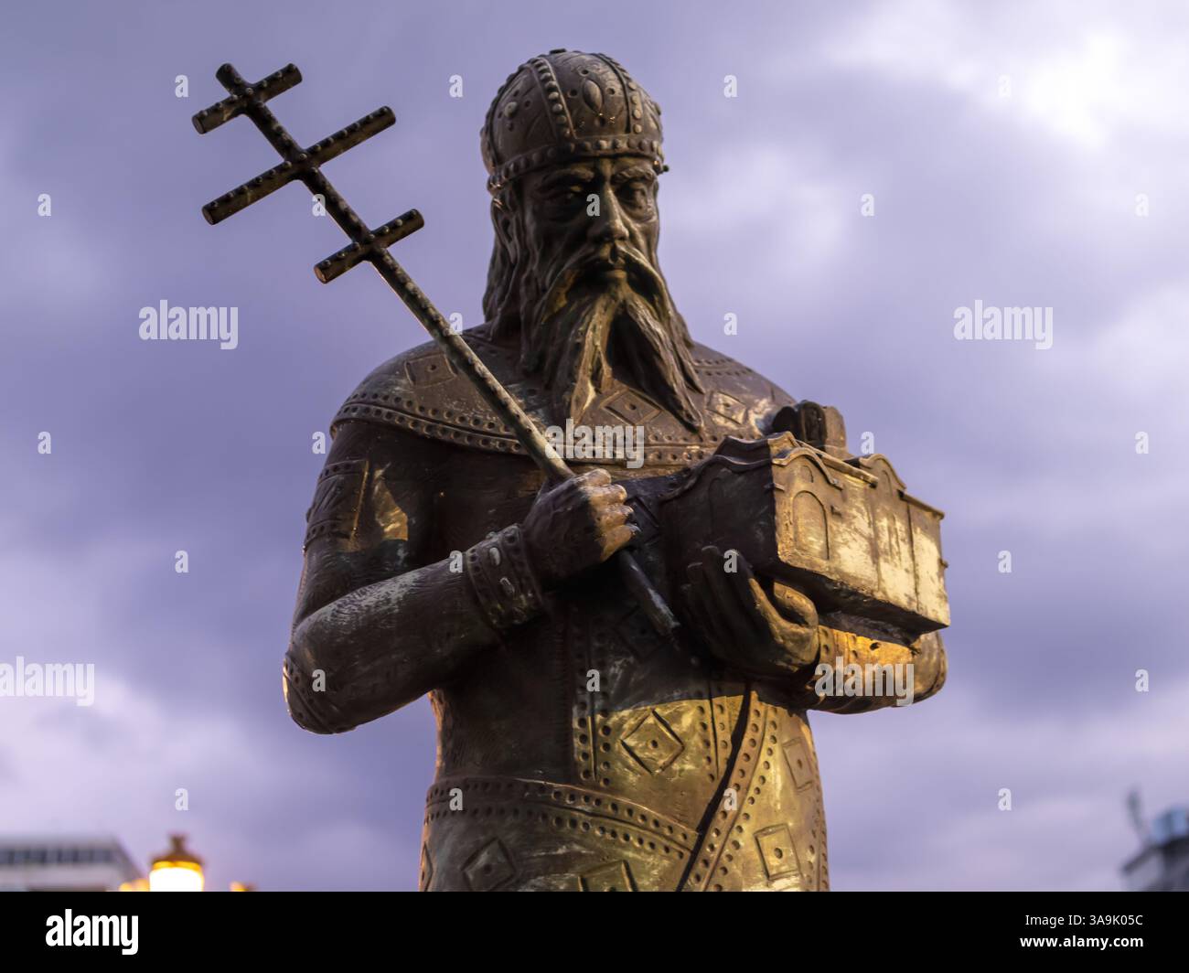 Bronzestatue einer orthodoxen religiösen Figur mit Kreuz und Miniaturkirche Stockfoto Bronzestatue einer orthodoxen religiösen Figur mit Kreuz und Miniaturkirche Stockfoto