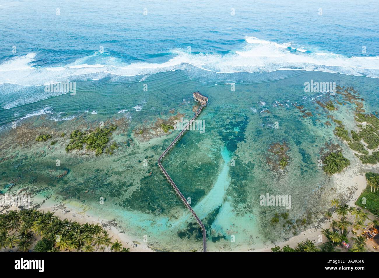 Atemberaubende Aussicht auf Cloud 9 Beach in Siargao aus der Vogelperspektive – Eine atemberaubende Strecke aus weißem Sand, türkisfarbenem Wasser und eine malerische Holzpromenade über dem Ozean Stockfoto